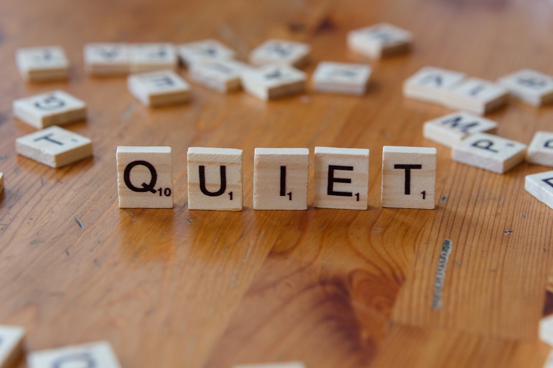 The word quiet spelled with wooden blocks on a table The word quiet spelled with wooden blocks on a table