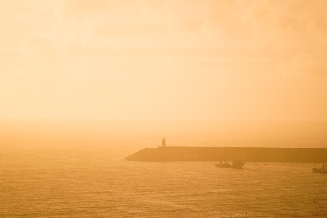 a large body of water with a lighthouse in the distance